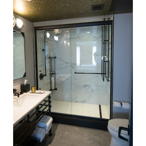 Frameless bypass enclosure with dark hardware and dark tile