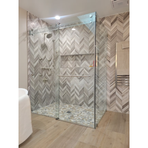 Frameless walk-in shower with herringbone tile and clear glass